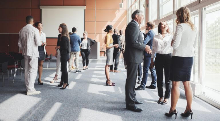 Groups of employees casually talking in corporate setting