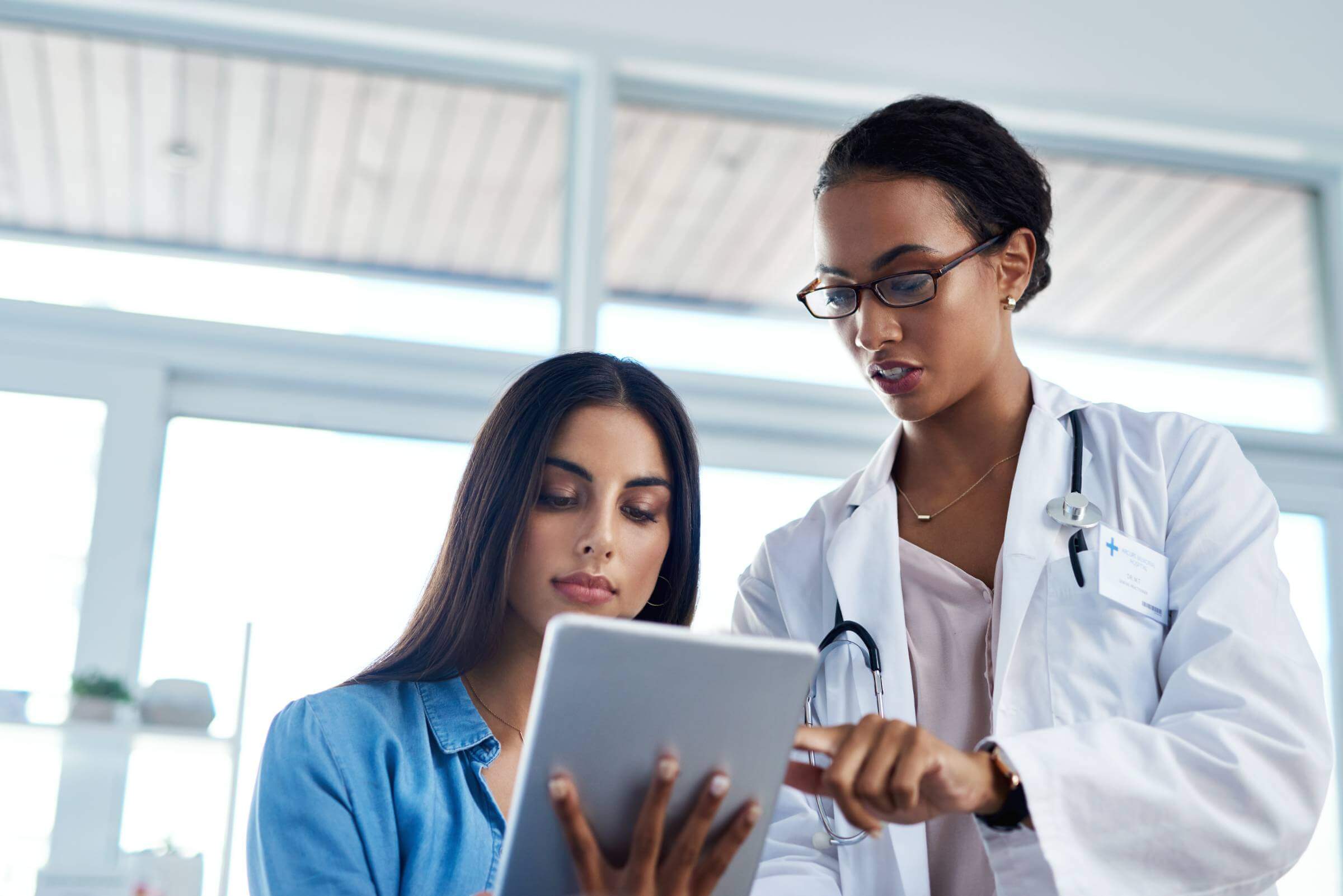 Shot of a young doctor using a digital tablet during a consultation with her patient.